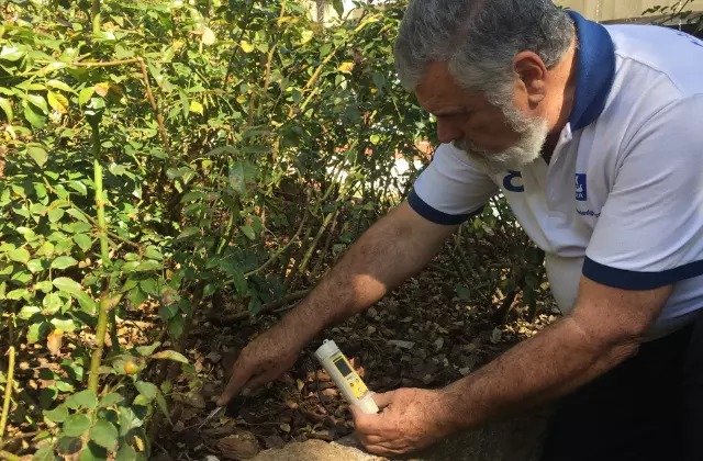 Homem mexendo na terra com equipamento na mão